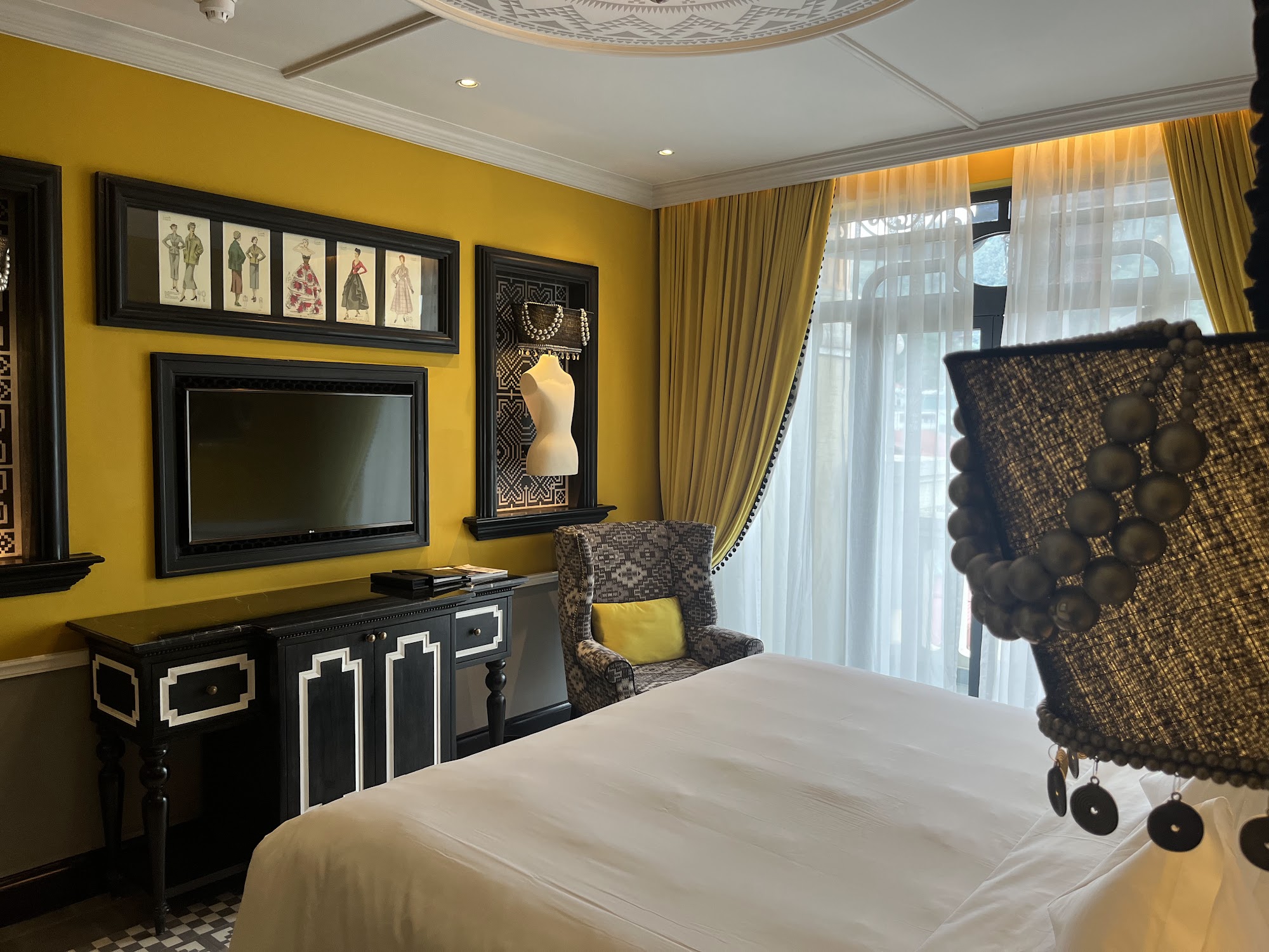 Hotel room with yellow walls and ornate decorations.